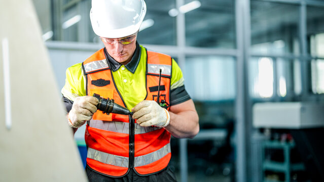 A technician in full PPE prepares for a shift in a smart factory cleanroom. He operates AI-driven industrial robots for high-tech microchip manufacturing. - Powered by Adobe