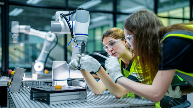 robotics engineer in an R&D lab performs diagnostics on an AI-driven collaborative robot (cobot). She is inspecting the hardware and system sensors.