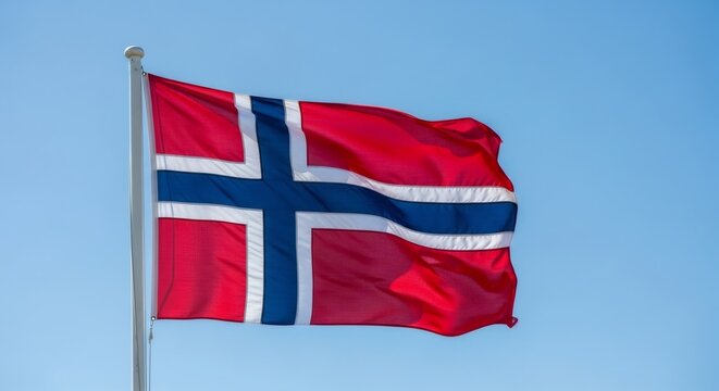 Norwegian flag waving proudly in the blue sky. National symbol for Norway independence day, celebration and patriotism concept. - Powered by Adobe