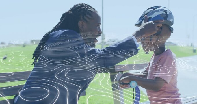 Adult male approaching placing helmet on boy and buckling for scooter safety, contours showing fit