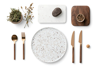 Stylish table setting featuring speckled plate, gold utensils, wooden elements, and decorative plants, creating elegant dining atmosphere