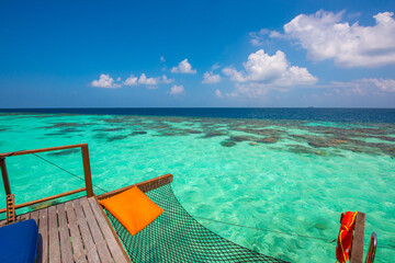 Tranquil closeup calm sea water waves with relaxing hammock. Summer vacation, holiday amazing nature. Relax paradise, Maldives. Tropical island beach landscape exotic shore coast. 