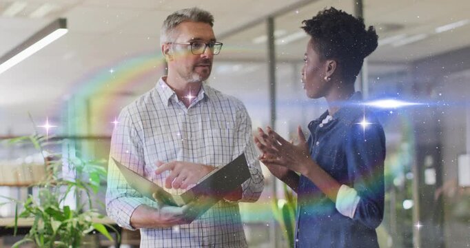 Manager pointing at folder initiating rainbow flares rising in business, woman nodding both smiling