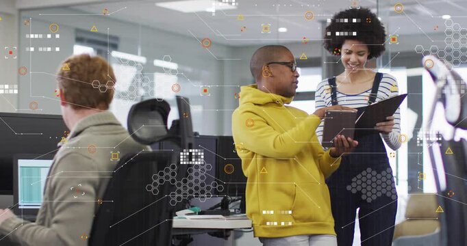 Man in yellow hoodie presenting tablet, woman with folder reviewing business data with HUD overlays