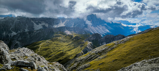Hiking in the Italian Alps. The Roda de Putia hiking route in the Dolomites. The trail to Mount Peitlerkofel. Colorful landscapes of the mountain range, hiking trails, and huts nearby.