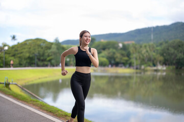 Woman jogging in park by lake enjoying healthy lifestyle