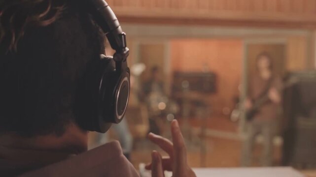 Music Producer Adjusts Sound While Band Records Live Track