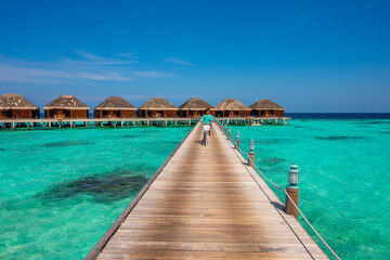 Woman riding bicycle. Tropical island beach landscape exotic shore coast. Tranquil closeup calm sea water waves with palm trees. Holiday amazing nature. Relax paradise, Maldives.