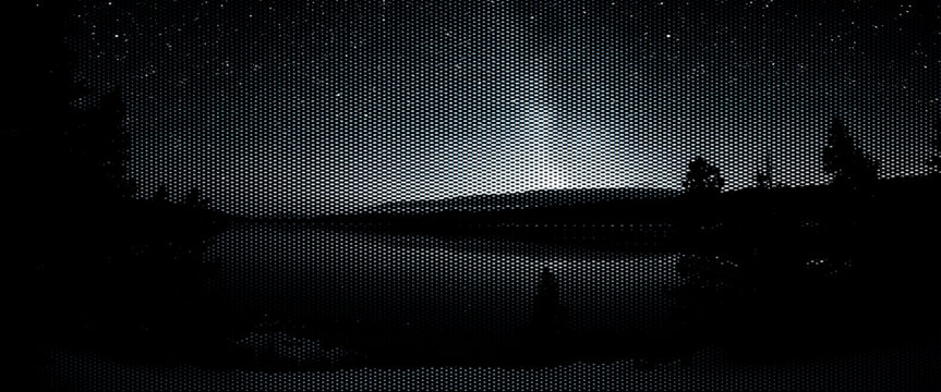 Northern nature's dark winter landscape features the moon and clouds over a blue lake reflecting the night sky light.