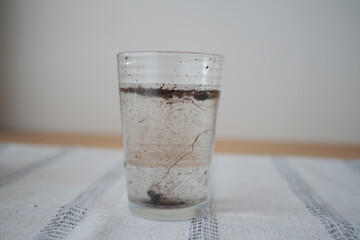 Water with sediment in clear glass on a table