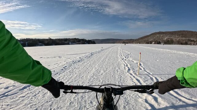 Fat Biking Across a Frozen Lake in Winter Wonderland - Scenic Adventure Cycling Experience. Exploring Frozen Lake Trails on a Fat Bike - Thrilling Winter Ride in Snowy Landscape.