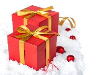 Two red christmas presents sit on white fake snow with gold ribbons and red ornaments, creating a festive and celebratory holiday scene.