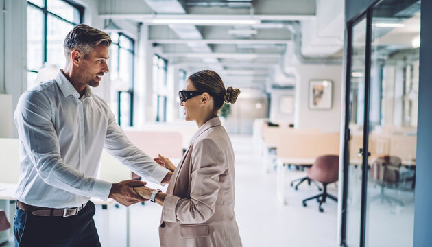 Coworker assisting blind colleague crossing modern office aisle, supportive teamwork, inclusive workplace, professional attire, bright open workspace, positive interaction