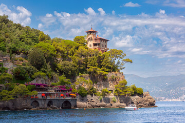 Seaside villa on rocky cliff surrounded by trees in Portofino, Italy, Liguria region