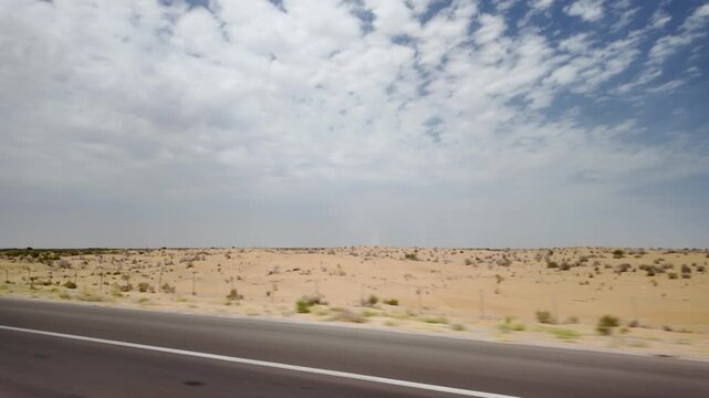 Driving on road through Karakum Desert landscape, Turkmenistan, Central Asia