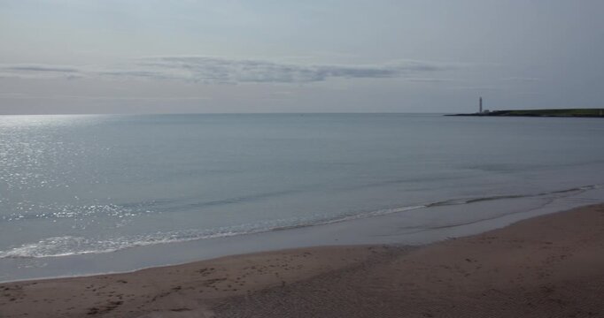 Extra wide panning shot of Montrose Beach with scurdie ness lighthouse.