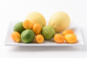 Fresh lemon, lime and kumquat on white background