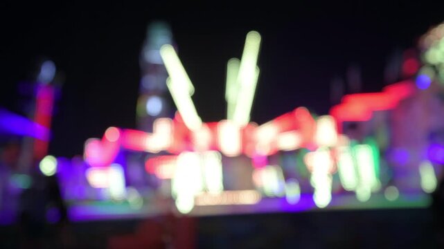 Out of focus amusement park ride lights lit up at the Minnesota state fair
