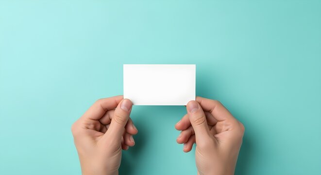 Two hands elegantly present a pristine, blank white business card against a vibrant teal background, offering a clear and customizable space for your unique message or brand identity