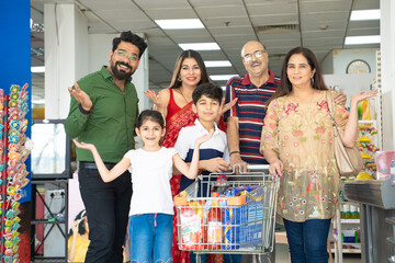 Indian family standing together at grocery shop.