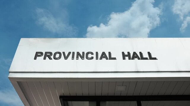 A Provincial Hall word sign displayed on a civic or government administration building under a clear blue sky, symbolizing regional authority, public policy, official management, and service