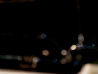 Abstract dark scene featuring blurred circular highlights and soft focus creating dreamlike mood.