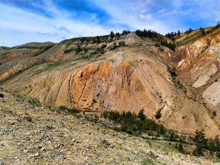 Layered clays and bright erosive forms in dry mountains. Wild natural landscape, clear sky and expressive geology.