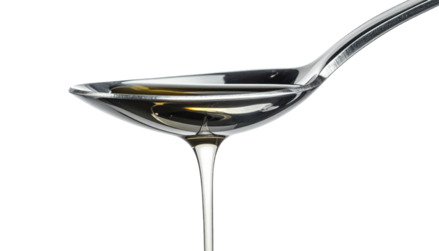 Spoon filled with clear liquid against a stark black background, capturing light reflection on the liquid's surface