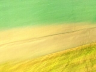 Blurred focus of lighting in warm yellow and green shades for background and decorations 