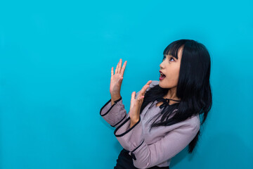 Fototapeta premium The woman reacts in surprise with open eyes and mouth, expressing shock and amazement. Ideal for reaction, lifestyle, and creative advertising.