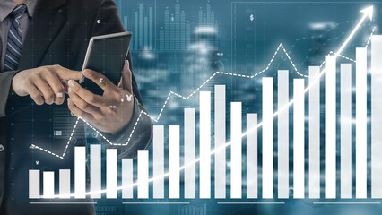A business professional studies financial data trends using a smartphone while surrounded by visuals of upward graphs and modern analytics. The image portrays success and progress. Copula