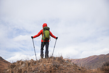 Backpacking woman hiking on winter high altitude mountain top