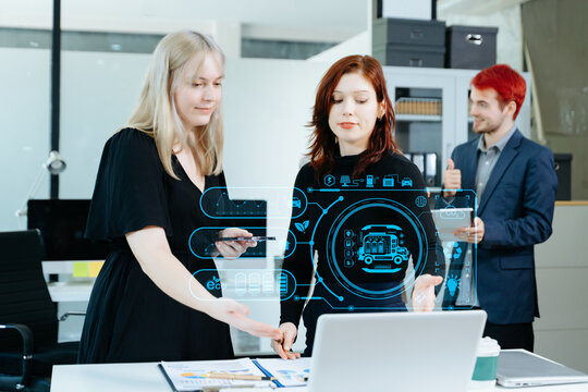 Business team collaborating with futuristic digital overlays on renewable energy, eco solutions, and innovation, symbolizing technology, teamwork, and sustainability.