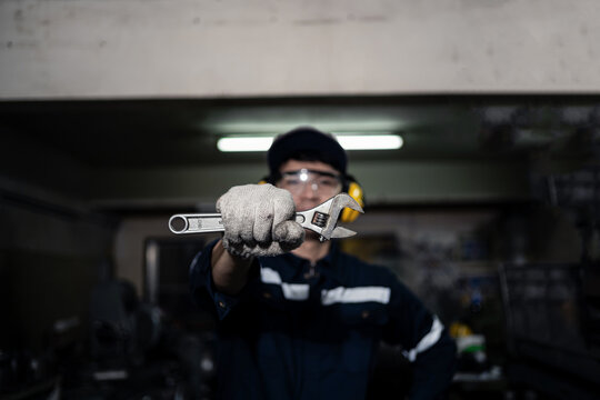 A man is working on a machine with a yellow and black safety vest on
