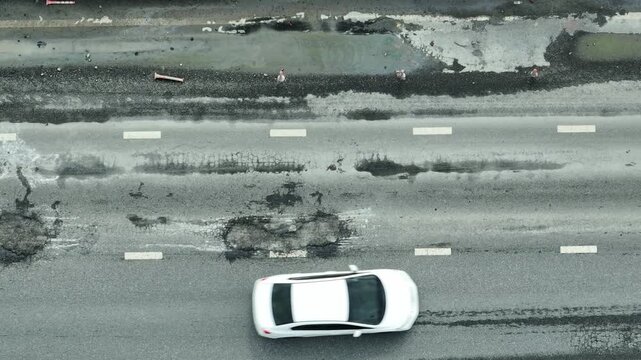 Potholes and cracks on the asphalt reveal the cost of delayed repairs, endangering drivers, stressing the environment, highlighting budget issues, urban growth, and planning deficiencies.
