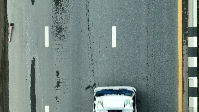 Drone view of a degraded city road highlights chronic neglect, driver safety issues, funding gaps, weak urban governance, weather impacts, and calls for investment in infrastructure. 4k video.
