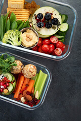 Bbox containing fresh fruits, vegetables, sandwiches, and nuts.