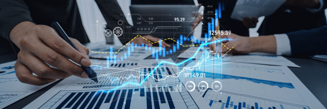 Business professionals are engaging in financial data analysis using digital tools and charts. The image captures collaboration and technology in action in a modern office setting. Scalp