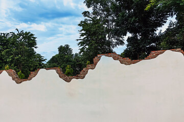 Decorative curved fence wall. Beautiful stuccoed brick wall features unique and attractive design, characterized by uneven, varying height levels. rendered brick wall design non uniform wall heights.