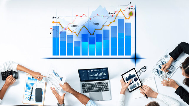 Business professionals collaborate in a modern workspace, analyzing data to drive growth. Laptops and charts highlight teamwork and strategic planning. Scalp