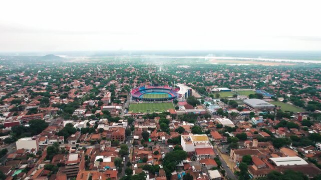 An aerial shot showcases the Estadio General Pablo Rojas stadium, locally known as La Nueva Olla, nestled within Asuncion, Paraguay. The surrounding urban landscape is dense