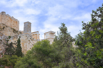 Fototapeta premium Ancient marble ruins of the Acropolis in Athens, Greece. Historic temple remains surrounded by greenery. Archaeology and classical heritage concept