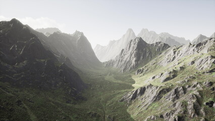 Fototapeta premium Lush green valley stretches between towering mountains under a clear sky. The sunlight softly illuminates the rocky terrain, creating a peaceful atmosphere at dawn.