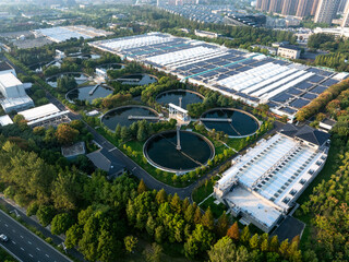 Aerial view of circular water treatment tanks, surrounded by greenery