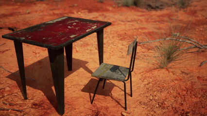 A vibrant red table and a worn metal chair sit alone in a vast, dry desert scene. The cracked ground surrounds this forgotten furniture, hinting at stories untold.