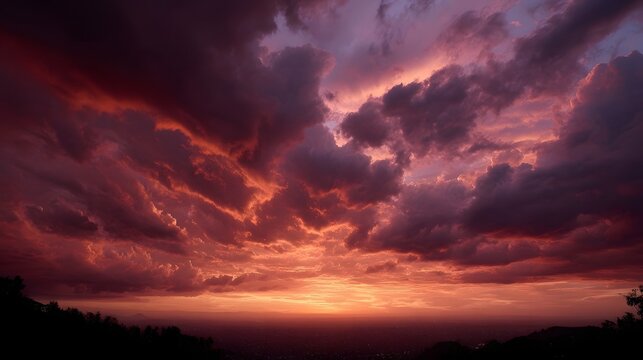 Dramatic crimson and purple clouds paint a vibrant sunset sky over a silhouetted landscape