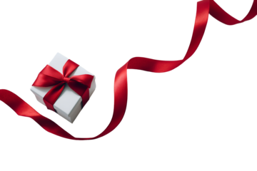 A minimalist, high-angle shot of a small, square gift box with a prominent, loosely tied red ribbon. The ribbon unfurls dramat on white or transparent background