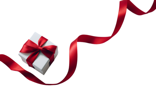 A minimalist, high-angle shot of a small, square gift box with a prominent, loosely tied red ribbon. The ribbon unfurls dramat on white or transparent background