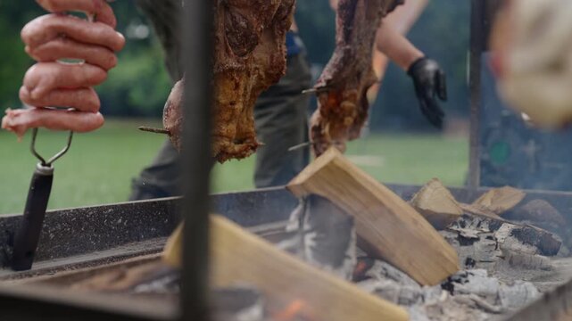 Traditional Argentinian asado with meat and sausages cooking over wood fire outdoors, authentic barbecue culture and culinary tradition