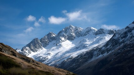 Panoramic view of a majestic snow capped mountain range under a clear blue sky